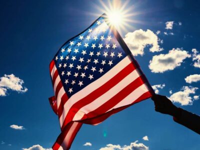American flag waving against a sunny blue sky - Law Offices of Miguel Martinez, P.C.